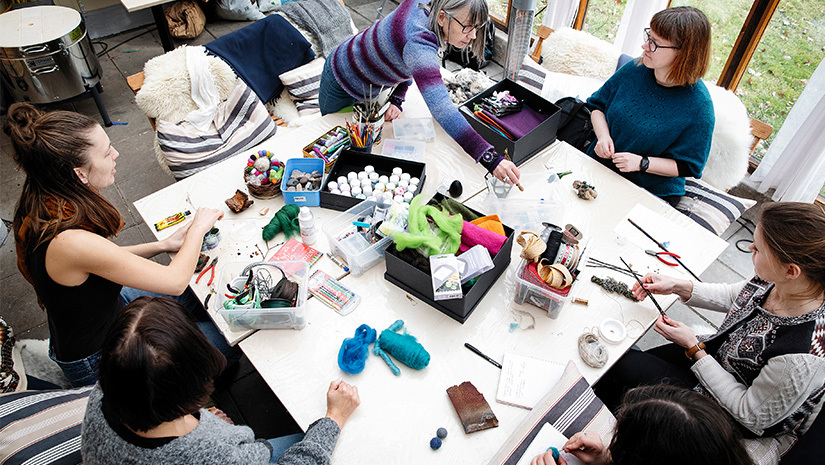 Nätverksmedlemmarna pysslar vid ett stort bord.