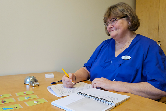 Isabel Johansson sitter vid ett bord med delar av KaTid-materialet.