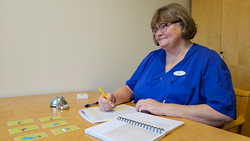 Isabel Johansson sitter vid ett bord med delar av KaTid-materialet.
