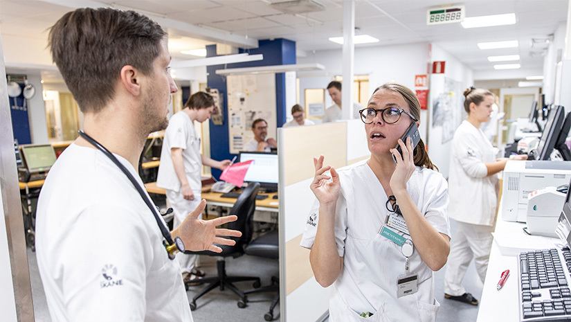 Arbetsterapeut Karin Strand i ett telefonsamtal och specialistläkare Jan Gebel bredvid henne.