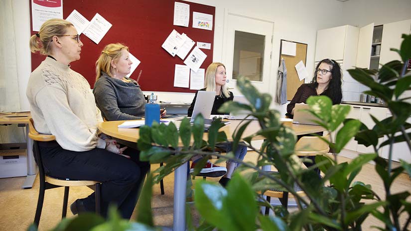 Teamet sitter och pratar runt ett bord.